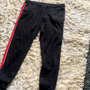 Black sweatpants with red and white stripe on side